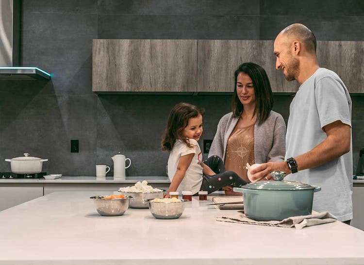 mom dad and daughter in the kitchen cooking