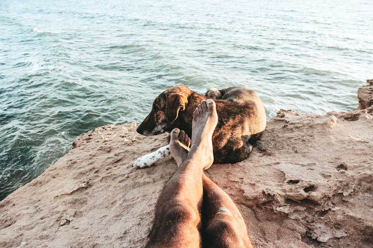 close up of feet sitting cross-legged by the water