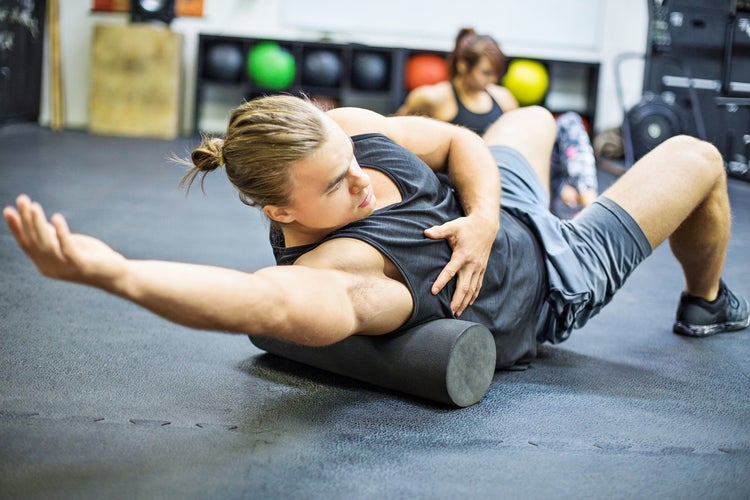 Man using a foam roller in the gym