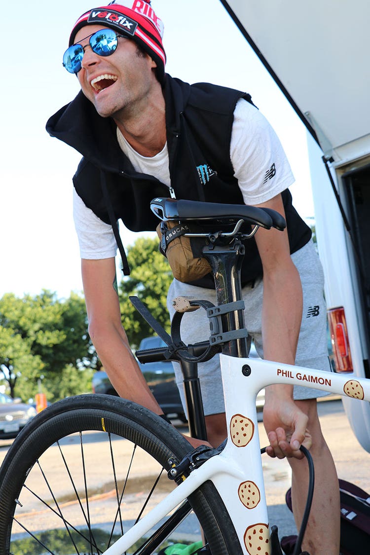 Phil Gaimon wearing street clothing and pumping air in a bike tire