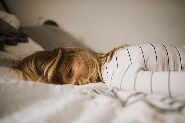 exhausted-person-lying-on-bed