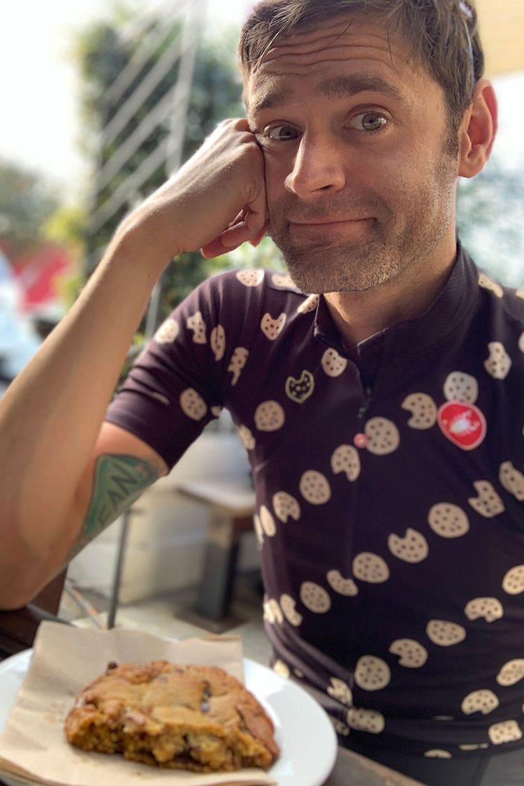 Phil Gaimon sitting with a cookie while wearing a cookie jersey